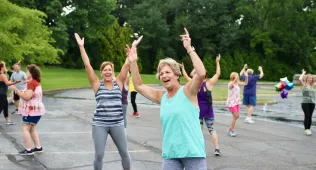 women with their hands up at a zumba class