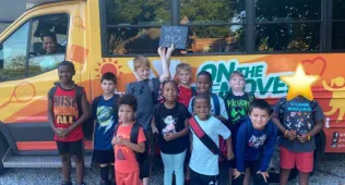 group of kids in front of a bus