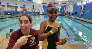 aquatics director pointing at a student swimmer who just got a green swim band