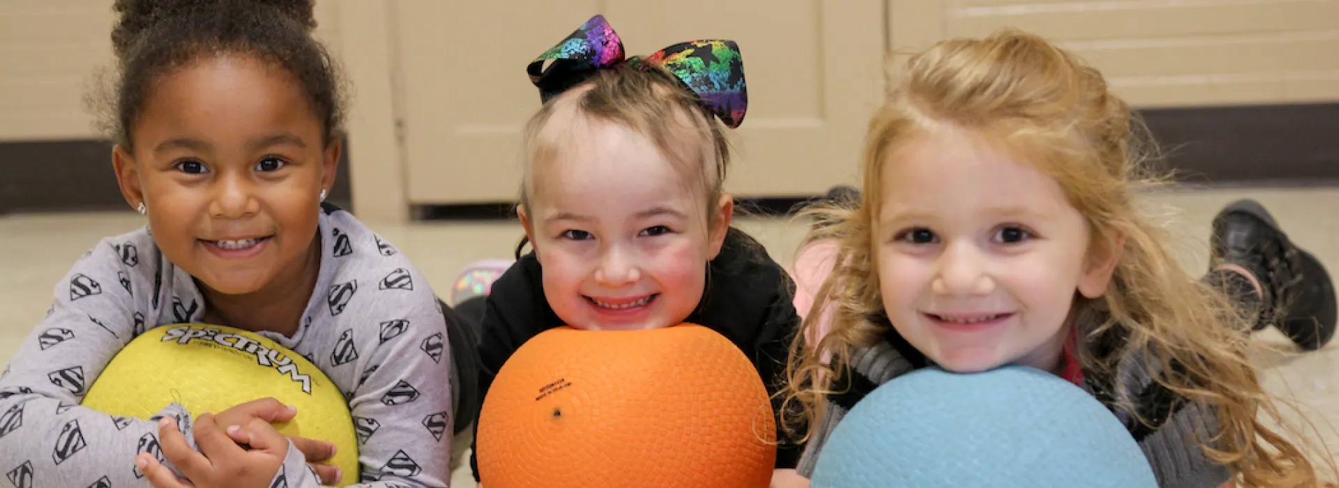three girls holding balls